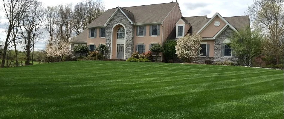 A large, green lawn in front of a two story home in Somerset County, NJ.