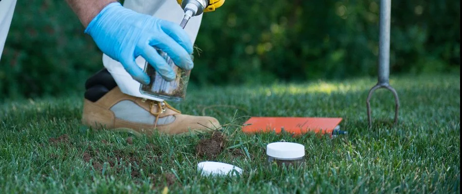 A worker in Wayne, NJ, with blue gloves testing soil.