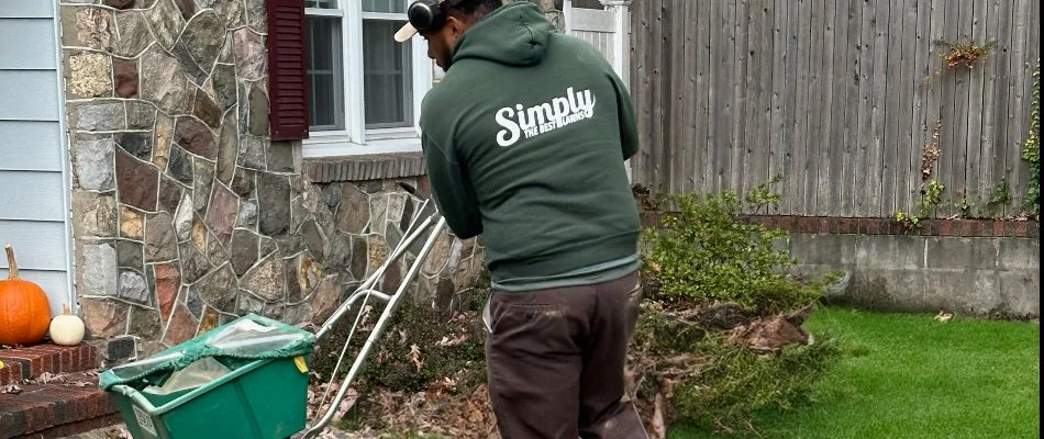 A worker in a green Simply The Best Lawns hoodie.